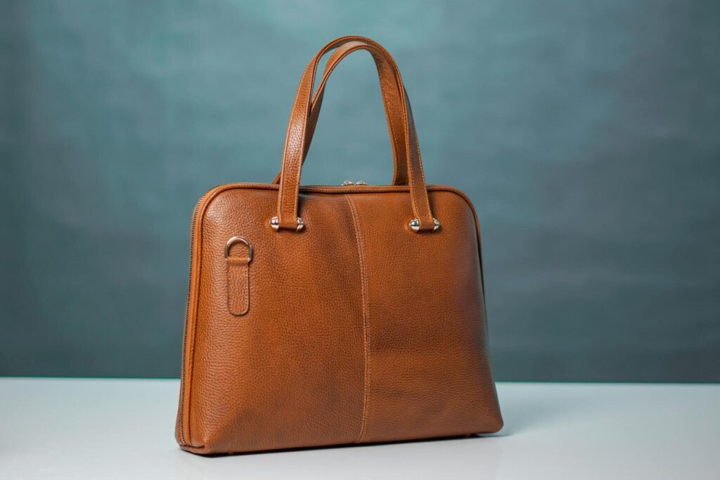 High-quality brown leather handbag against a neutral background.